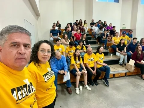 Integrantes de DESTACA reunidos en gradas durante un evento comunitario.