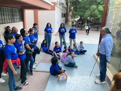 Visita guiada en el campus universitario con un investigador explicando al grupo.